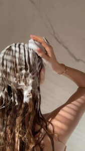 Como lavar o cabelo corretamente mulher lavando o cabelo.